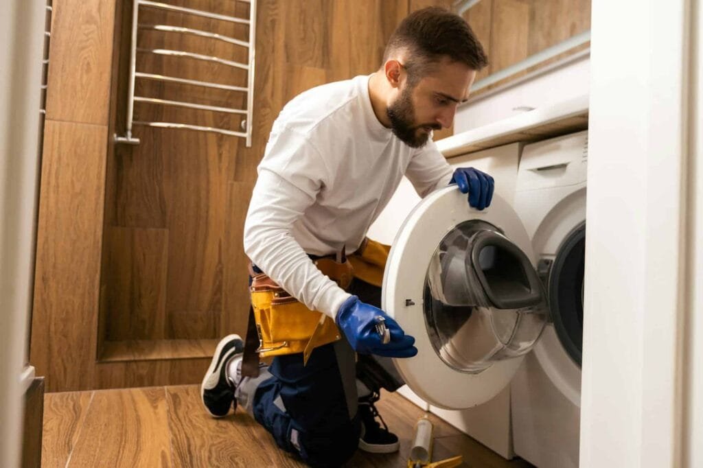 Appliance repair expert fixing broken washing machine – Professional repair service.