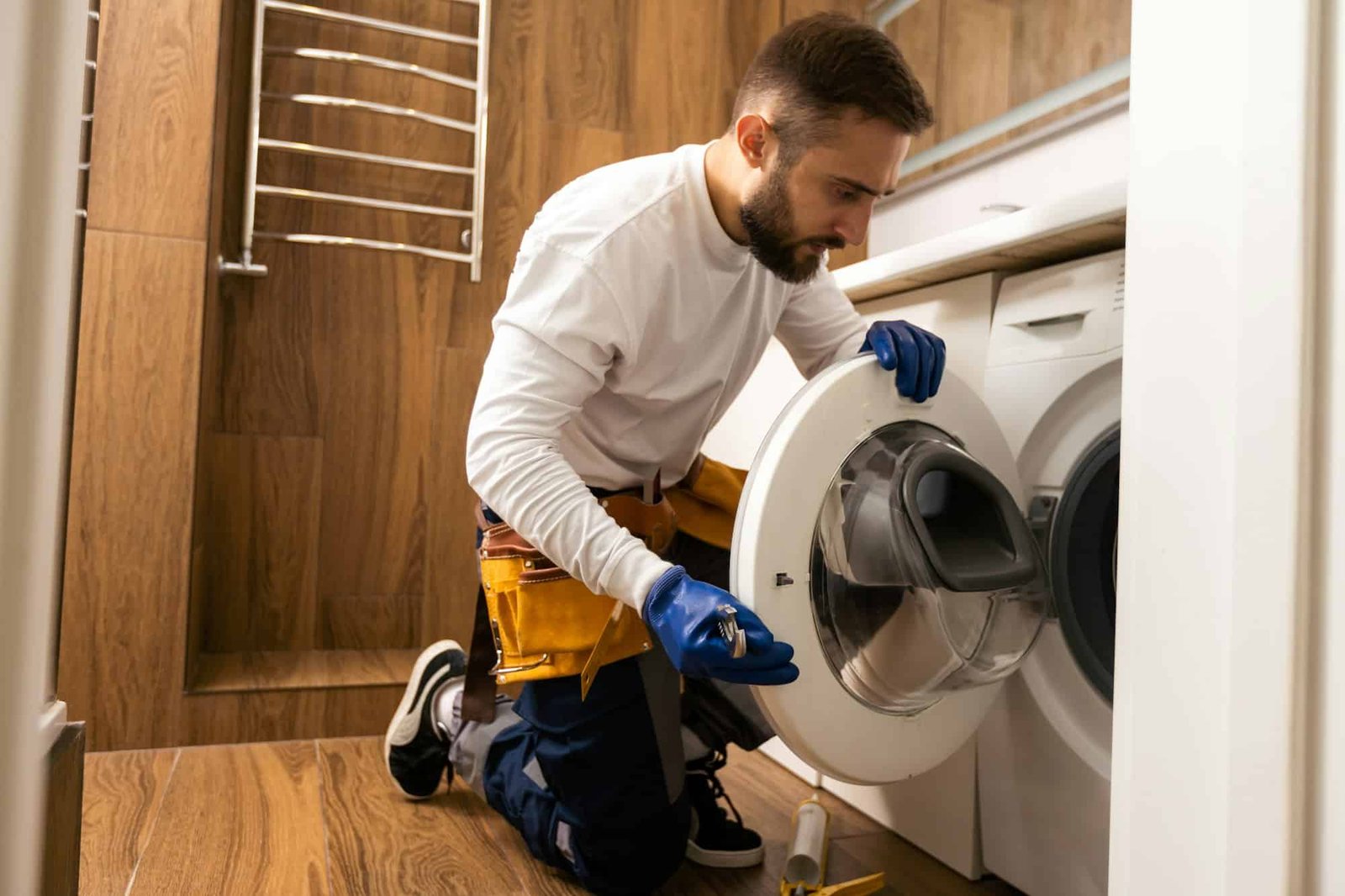 Appliance repair expert fixing broken washing machine – Professional repair service.