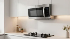 Sleek modern over-the-range microwave installed above a kitchen stove in a brightly lit home kitchen.